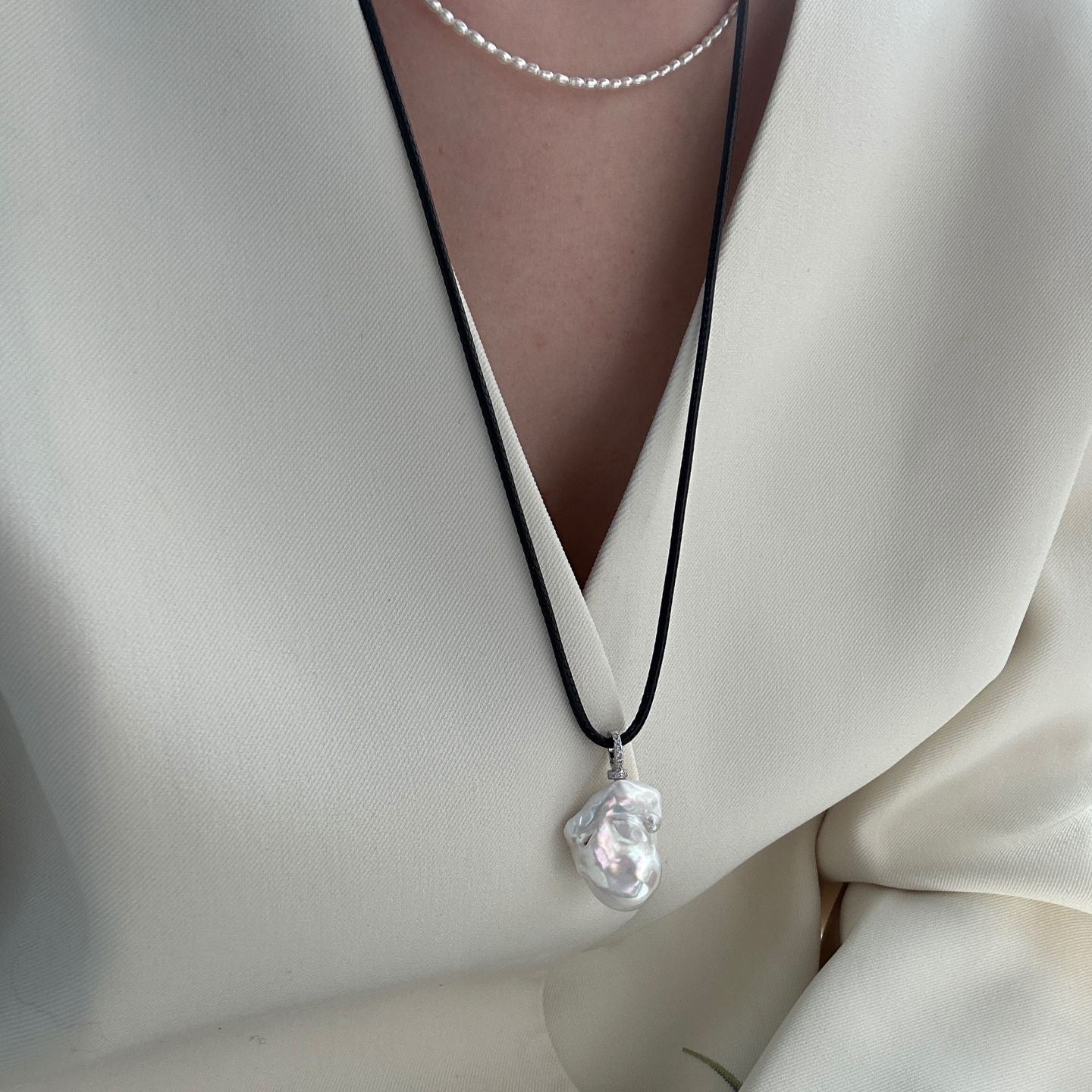 Necklace with a clear pendant on a white outfit
