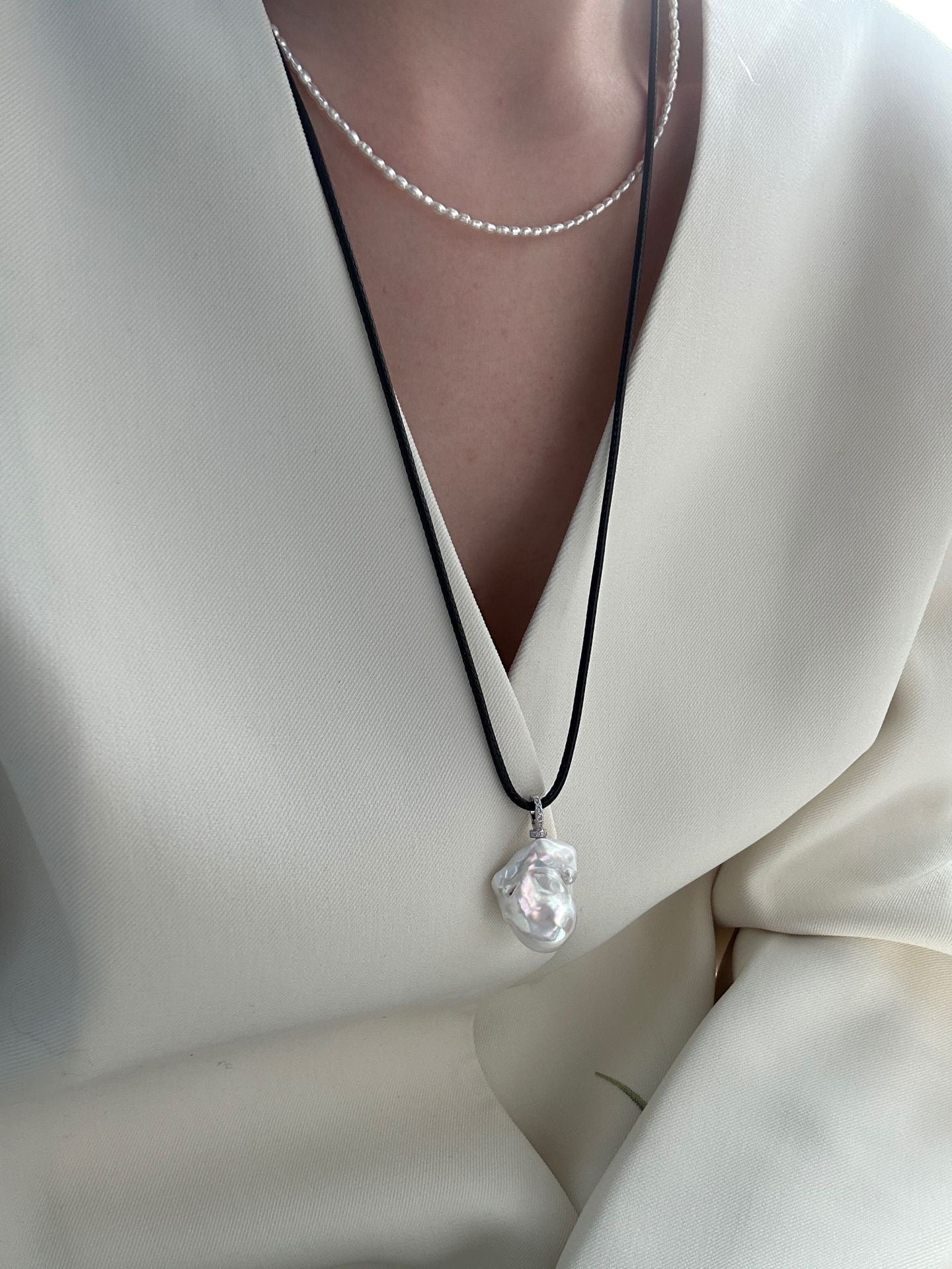 Necklace with a clear pendant on a white outfit