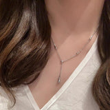 Necklace worn by a person with a visible brand logo on a neutral background