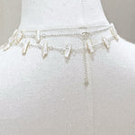 Silver chain belt on a mannequin with a plain background