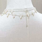 Silver chain belt on a mannequin with a plain background